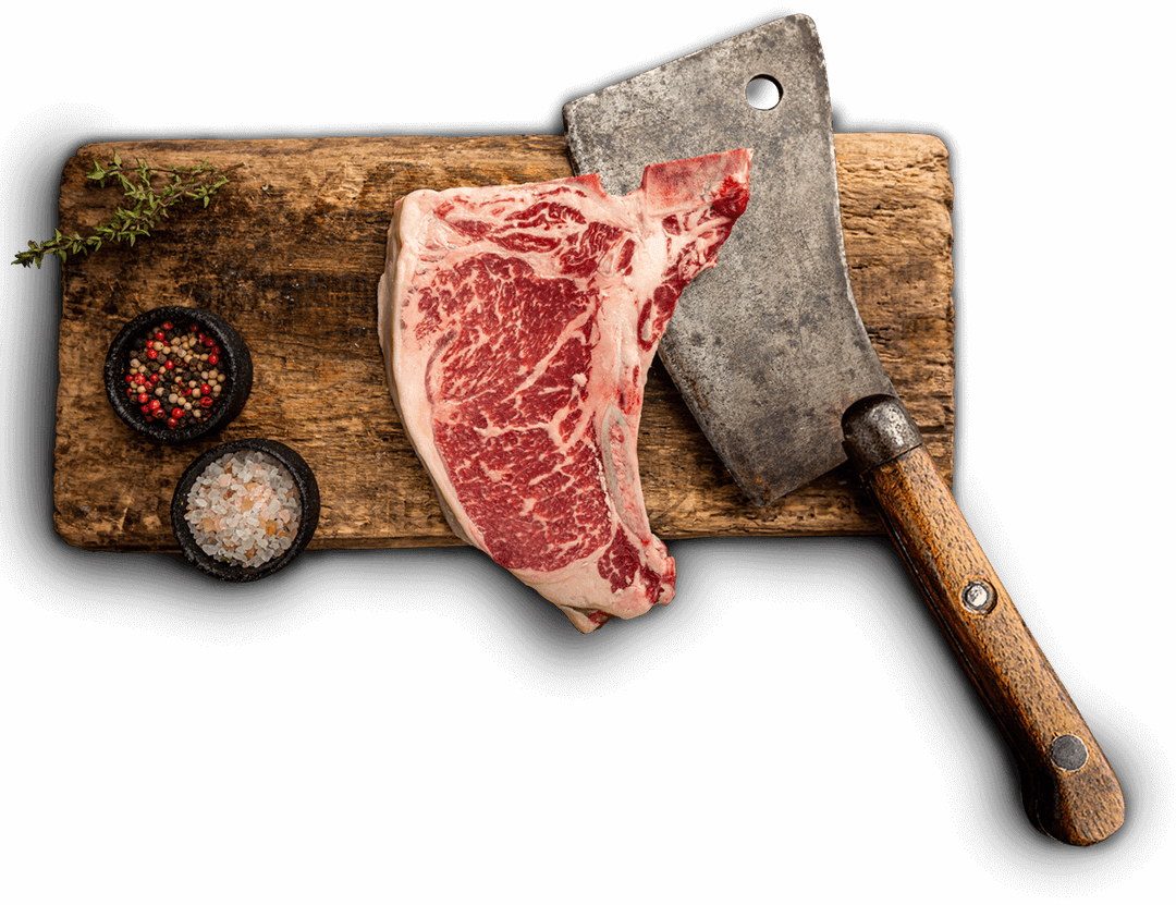 Premium T-bone steak on wooden cutting board with cleaver and seasonings